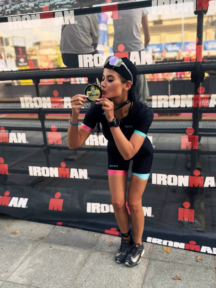 Olga Pabjan całuje medal po ukończeniu triathlonu Ironman 70.3 w Poznaniu